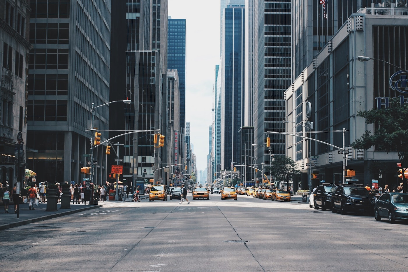 Multi-lane highway with vehicles and city buildings alongside the road.
